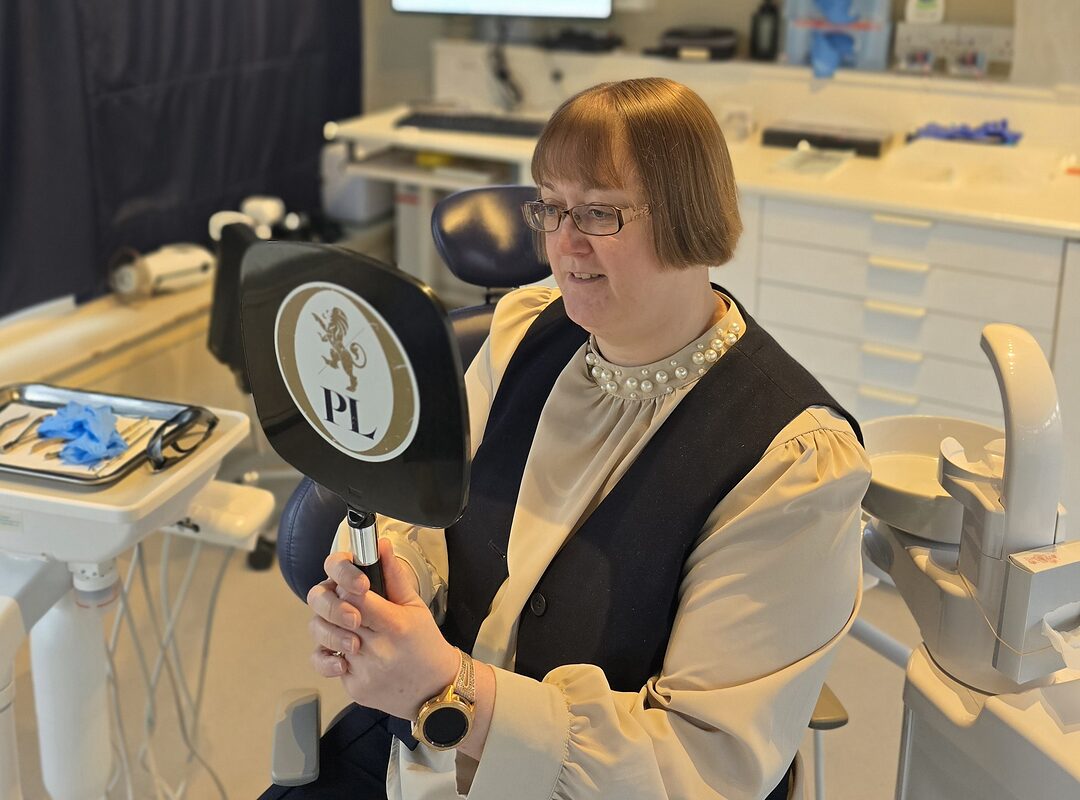 Park Lane Orthodontics team member holding a branded hand mirror in the treatment room