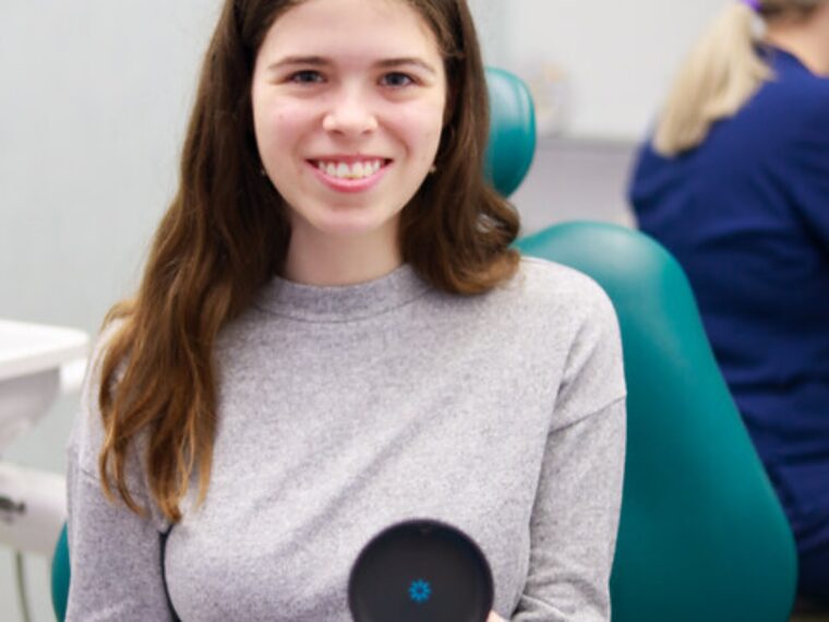 Young Park Lane Orthodontics patient in the treatment chair holding her clear aligner case